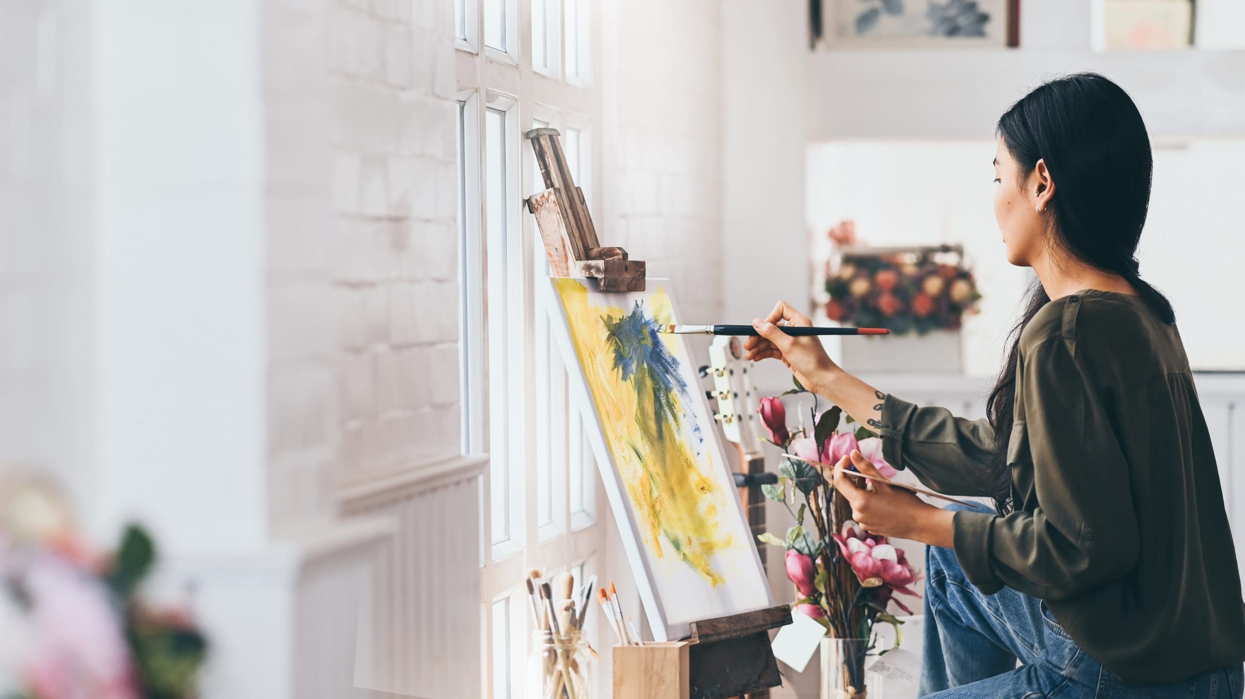 Woman painting a canvas on easel